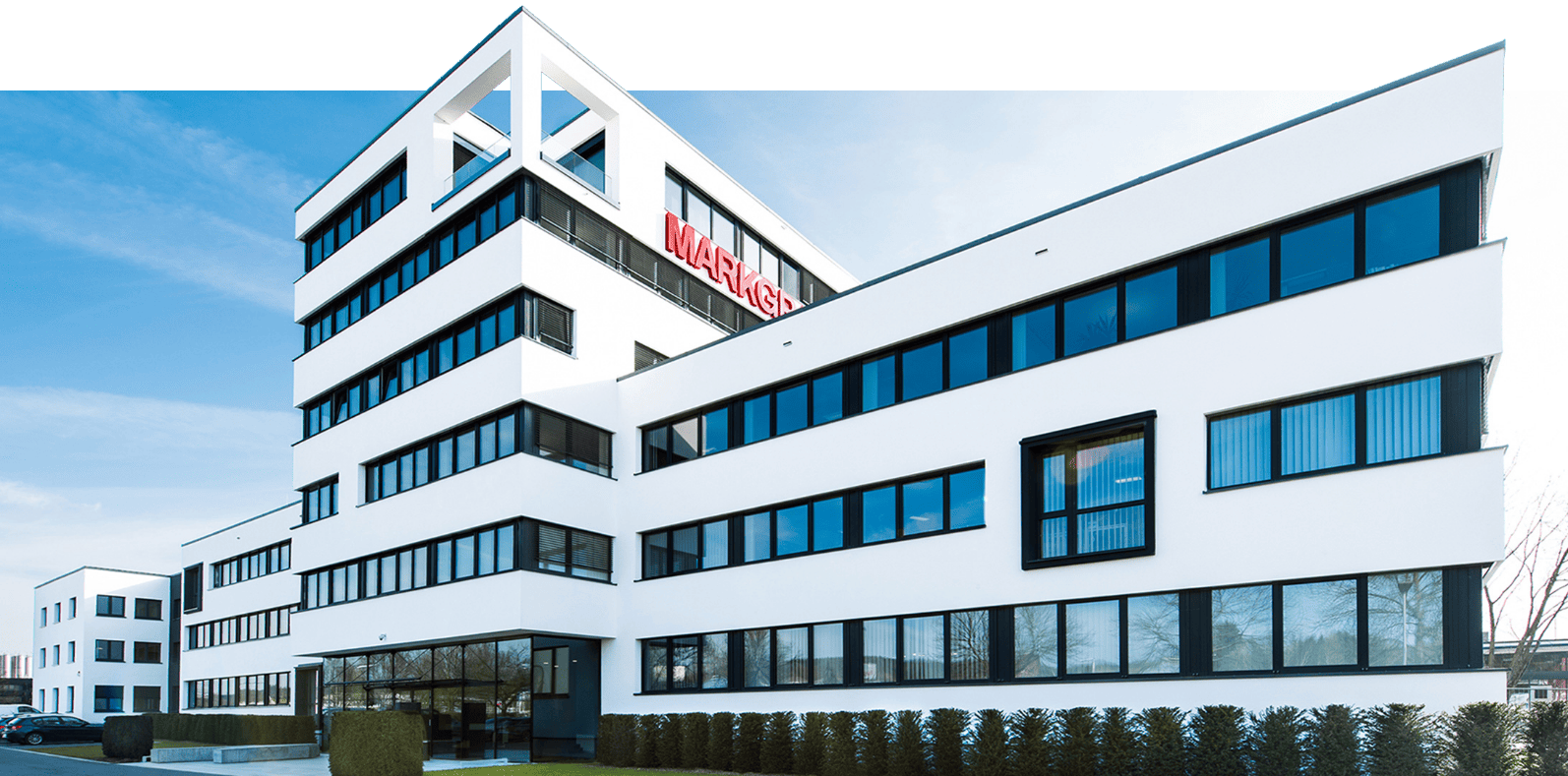 Modernes Bürogebäude der Firma Markgraf mit weißer Fassade und schwarzen Fensterrahmen